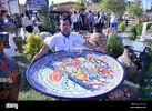 kokand-uzbekistan-13th-sep-2019-a-craftsman-displays-a-giant-plate-during-the-international-h...webp