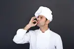 male-chef-kissing-fingers-against-grey-background-37021589.webp